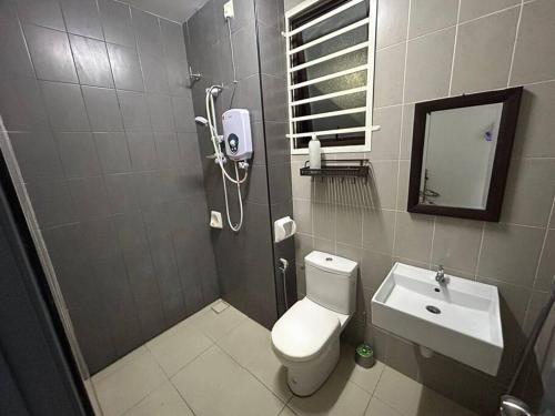 a bathroom with a toilet and a sink and a mirror at 69 S2 Heights, Ainsdale # U Homestay in Seremban