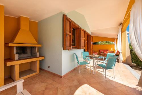 a kitchen and dining room with a table and chairs at Domixedda in Costa Rei