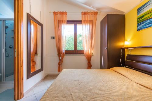 sypialnia z łóżkiem i oknem w obiekcie Domixedda w mieście Costa Rei