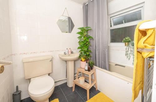 a small bathroom with a toilet and a sink at Xtra Large 4 Bedroom House, near Excel, London City and 5 walk to Train Station in London
