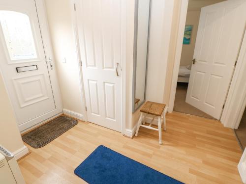 Habitación con puerta, silla y alfombra azul en Lower Driftwood, en Amble