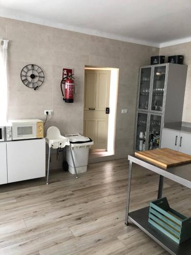 a kitchen with white cabinets and a table and a microwave at Cortijo Amaya in Torrox Costa