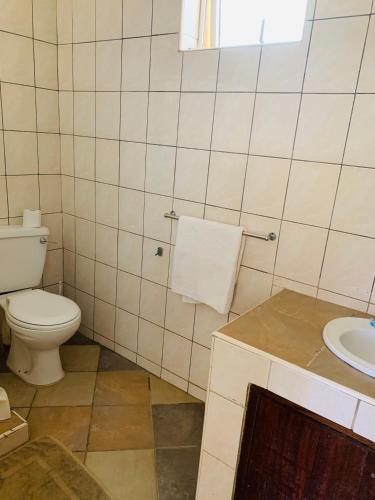 a bathroom with a toilet and a sink at Ltorec in Nyali