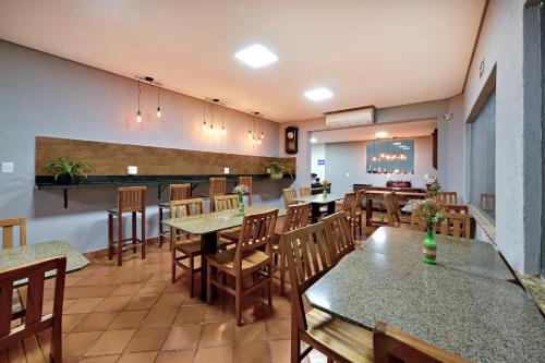 a restaurant with tables and chairs and a bar at HOTEL Vitoria in Ribeirão Preto