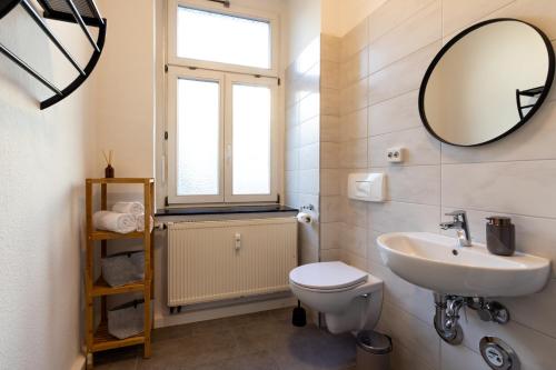 ein Badezimmer mit einem Waschbecken, einem WC und einem Spiegel in der Unterkunft Business & Life Apartment nähe TU, HBF und Oper - SmartTV, MagentaTV und Küche in Chemnitz