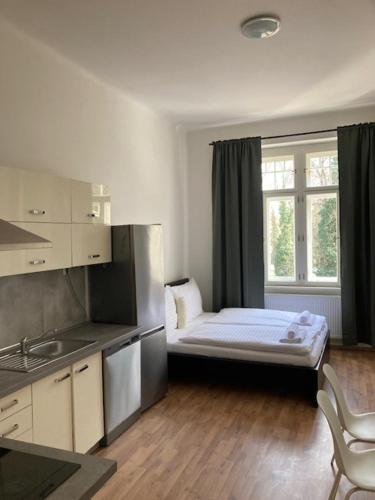 Habitación pequeña con cama y ventana en Erbenova Apartments, en Praga