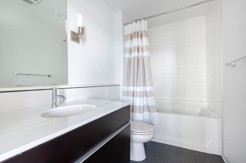 a bathroom with a sink and a toilet and a shower at Downtown Bellevue Studio w Gym WD nr shops SEA-117 in Bellevue