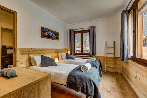 a bedroom with two beds and a table at Chalet des Sapins in Chamonix-Mont-Blanc