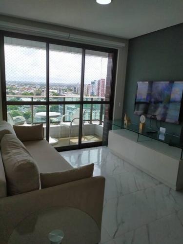 a living room with a couch and a flat screen tv at Jardins da Madalena in Recife