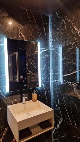 uma casa de banho com um lavatório branco e um espelho. em Medusa spa 34* em Montpellier