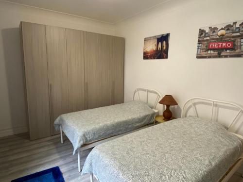 リスボンにあるMaiur Apartmentのベッド2台とキャビネット付きの部屋