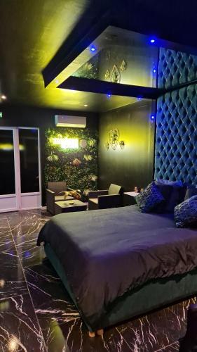 1 dormitorio con 1 cama grande con luces azules en Medusa spa 34* en Montpellier