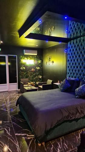 - une chambre dotée d'un grand lit avec des lumières bleues dans l'établissement Medusa spa 34*, à Montpellier