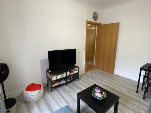 a living room with a flat screen tv and a table at Maiur Apartment in Lisbon