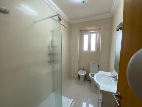 e bagno con doccia, servizi igienici e lavandino. di Maiur Apartment a Lisbona