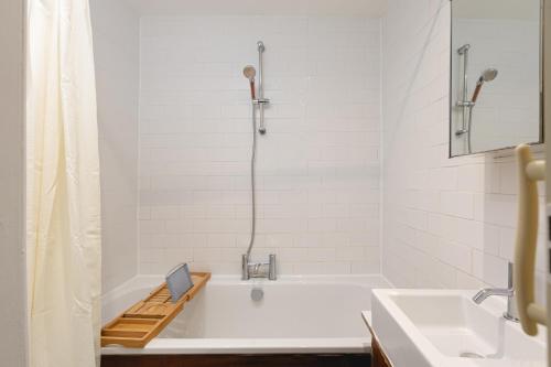 ein Badezimmer mit einer weißen Badewanne und einem Waschbecken in der Unterkunft 2 bed 2 bath APT Central London in London