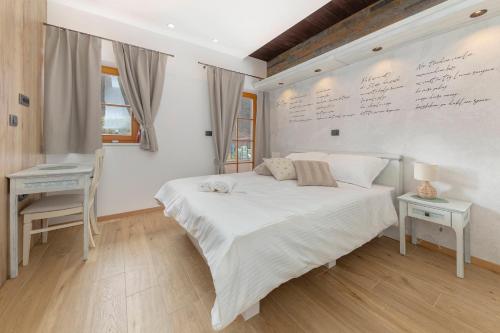 a bedroom with a white bed and a desk and a desk at Farm Stay Ivankotovi in Prem