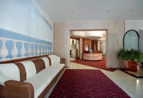 ein Wohnzimmer mit einer weißen Couch und einem roten Teppich in der Unterkunft Hotel Souvenir in Bellaria-Igea Marina
