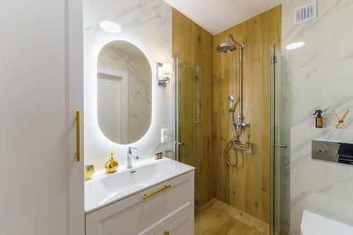 a bathroom with a sink and a shower at Aquabaltic Apartments Aquarius II in Kołobrzeg