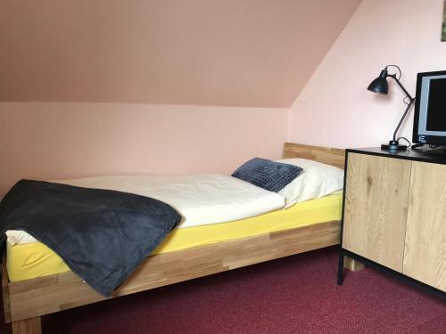 Schlafzimmer mit einem Bett und einem Schrank mit einem TV in der Unterkunft Haus am Leuchtturm (EZ) in Neuharlingersiel