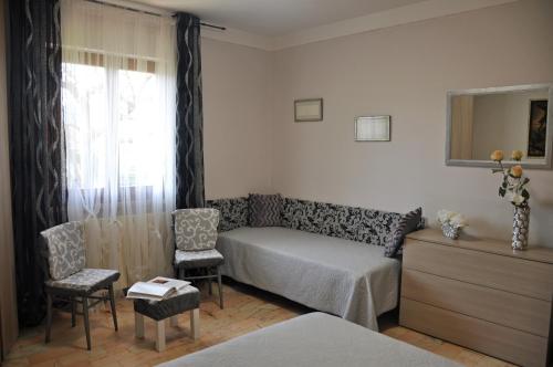 - une chambre avec un lit, deux chaises et une fenêtre dans l'établissement Casa in campagna a tre chilometri dal mare con parcheggio privato, à Querceta