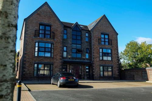 a car parked in front of a brick building at LUXURY TOWN CENTRE APARTMENT in Cookstown