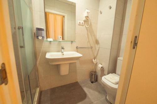 Un baño con lavabo, inodoro y ducha. en Hostal Live Natura Barcelona, en Barcelona