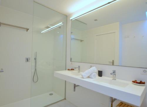 une salle de bain avec un lavabo, une douche et un miroir dans l'établissement Villa Sant Carles, à Port d’Andratx