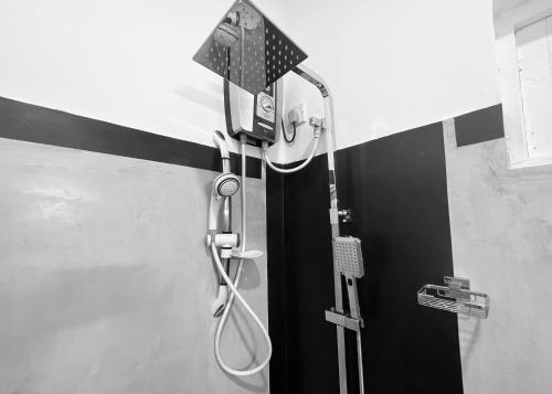 a shower with a shower head in a bathroom at The Lake Round Guest House in Kandy