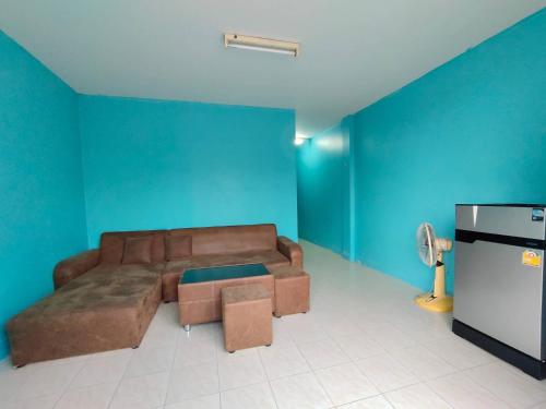 Ban Khok Mo的住宿－บ้านพักทนายบ้านนอก 2，客厅设有棕色沙发和蓝色的墙壁。