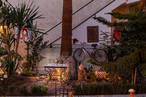 a table and a tree in front of a house at Riad 4 jardins in Marrakesh