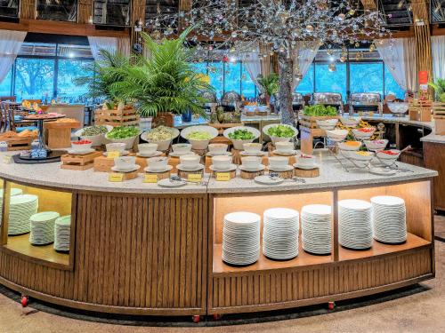 a table with plates and dishes on it at Serena Kim Boi Resort - Hoa Binh in Hòa Bình