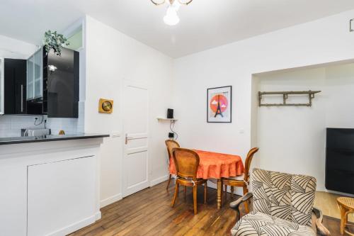 - un salon avec une table, des chaises et une télévision dans l'établissement Nice 34m well located - Montmartre district, à Paris