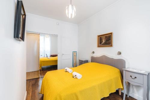 - une chambre dotée d'un lit jaune avec un ours en peluche dans l'établissement Nice 34m well located - Montmartre district, à Paris