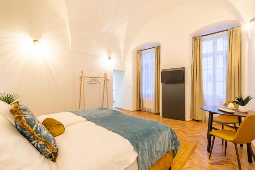 a bedroom with a bed and a table in a room at Primavera - Castle view apartments in Prague