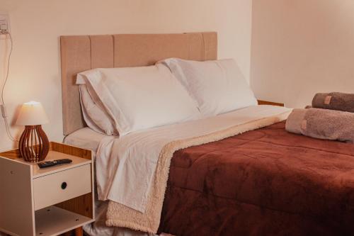 a bedroom with a bed and a night stand with a lamp at Vila Espinhaço in Diamantina