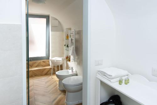 a bathroom with a toilet and a sink and a mirror at Residenza Echia in Naples