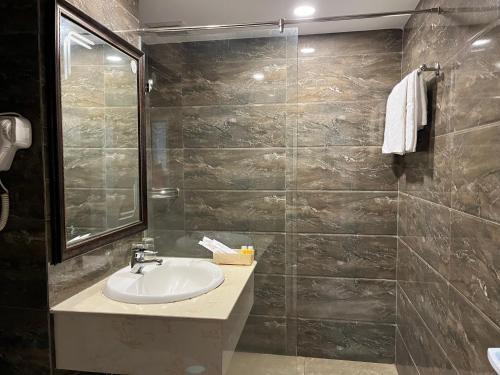 a bathroom with a sink and a tiled wall at Phung Long Hotel in Ho Chi Minh City