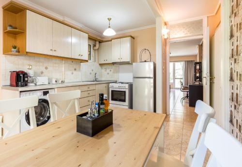 uma cozinha com uma mesa de madeira e um frigorífico em Glyfada 2 bedrooms 4 persons apartment by MPS em Atenas