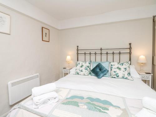 ein Schlafzimmer mit einem großen weißen Bett mit blauen Kissen in der Unterkunft The Bathing House in Ashsprington
