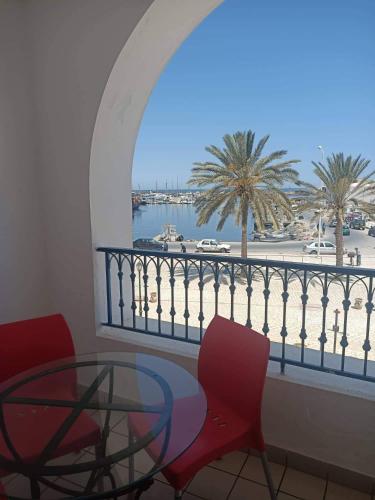 balcón con mesa, sillas y vistas al agua en EL MANZEl 102 en Houmt El Souk