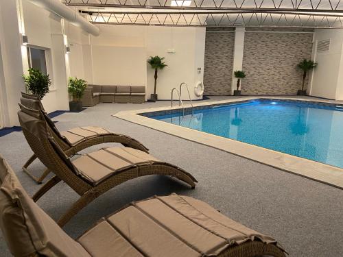 uma piscina de hotel com cadeiras e uma piscina em Pentire Hotel em Newquay