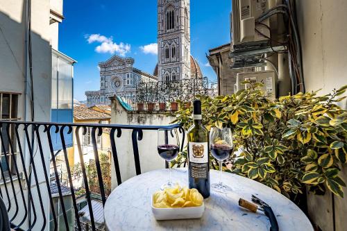 a table with a bottle of wine and glasses on a balcony at Residenza Giotto in Florence