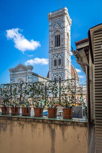 a building with a clock tower and potted plants on a ledge at Residenza Giotto in Florence