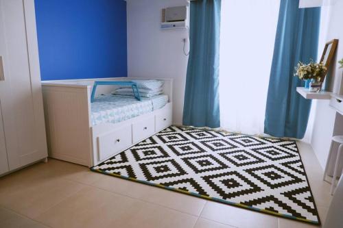 a small room with a bed and a rug at Santorini at Vertis North in Manila