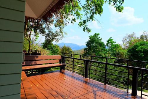 a wooden deck with a bench on a balcony at The Triple M Mountain Resort in Ban Muang Ton Mamuang