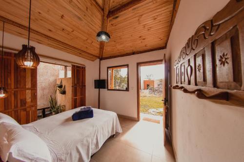 ein Schlafzimmer mit einem Bett in einem Zimmer mit Holzdecken in der Unterkunft Vila Espinhaço in Diamantina