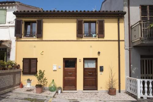 a yellow house with brown doors and windows at Grazioso Bilocale a 5 minuti da Numana in Numana