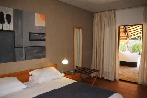 a bedroom with a bed and a table and a window at Central Hotel Omaruru in Omaruru