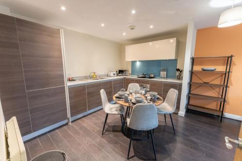 a kitchen and dining room with a table and chairs at JOIVY Modern flats in central Birmingham, next to business district in Birmingham